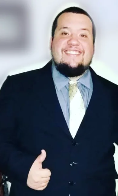 Benji, de traje, sonriendo con el pulgar arriba